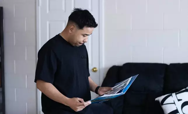 Army Sgt. Hedar Leonel Turcios Juarez, whose wife Cristy has been detained by immigration authorities, looks at family photos at home in El Paso, Texas, July 21, 2026. (AP Photo/Ryan Romero)