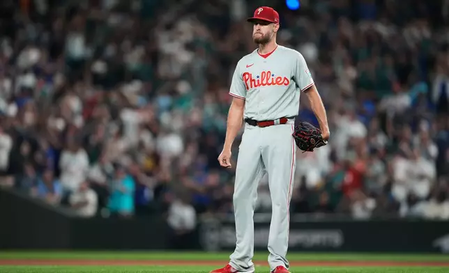 Philadelphia Phillies starting pitcher Zack Wheeler reacts after giving up back-to-back home runs to Seattle Mariners' Cal Raleigh and Cole Young during the fifth inning of a baseball game, Monday, Aug. 24, 2026, in Seattle. (AP Photo/Lindsey Wasson)
