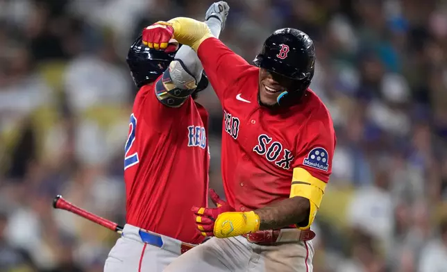 Boston Red Sox's Ceddanne Rafaela, right, celebrates with Wilyer Abreu after hitting a two-run home run during the seventh inning of a baseball game against the Los Angeles Dodgers, Friday, July 31, 2026, in Los Angeles. (AP Photo/Mark J. Terrill)