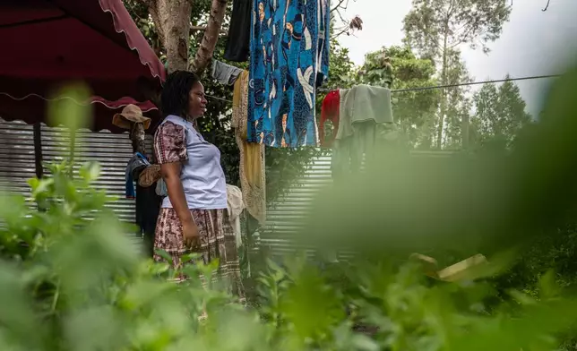 Esther Lutula, a 26 year-old woman who is four months pregnant and a mother of four, who stopped going for prenatal checkups shortly after the current Ebola outbreak, stands outside her house in Bunia, northeastern, Congo, Tuesday, June 16, 2026. (AP Photo/Moses Sawasawa)