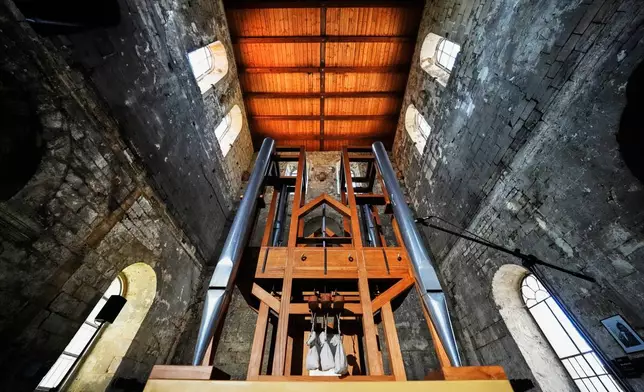 The organ, center, of the John Cage Organ Project Halberstadt is illuminated prior to a chord change of the organ inside the medieval Burchardi Church in Halberstadt, Germany, Wednesday, Aug. 5, 2026. (AP Photo/Markus Schreiber)