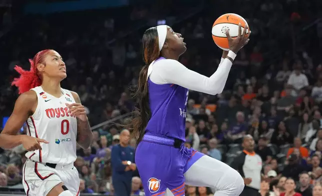 Phoenix Mercury guard-forward Kahleah Copper, right, drives past Washington Mystics center Shakira Austin (0) to score during the first half of a WNBA basketball game, Thursday, Aug. 27, 2026, in Phoenix. (AP Photo/Ross D. Franklin)