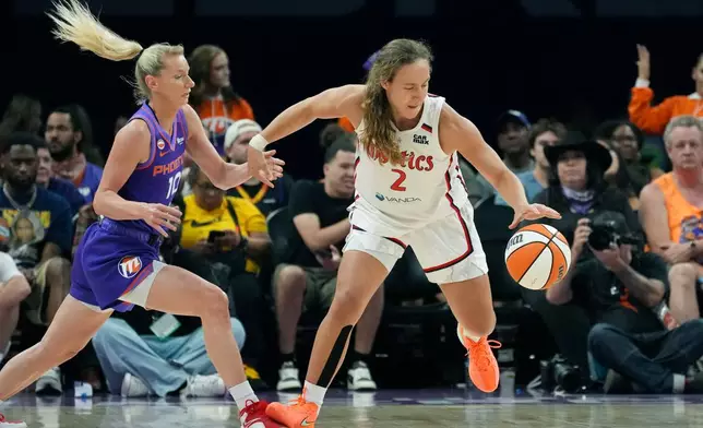 Washington Mystics guard Alicia Florez (2) gets fouled by Phoenix Mercury guard Lexi Held (10) during the first half of a WNBA basketball game, Thursday, Aug. 27, 2026, in Phoenix. (AP Photo/Ross D. Franklin)