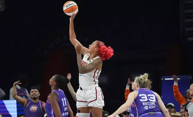 Washington Mystics center Shakira Austin, center, shoots over Phoenix Mercury forward Valeriane Ayayi (11) as Mercury guard Sami Whitcomb (33) looks on during the first half of a WNBA basketball game, Thursday, Aug. 27, 2026, in Phoenix. (AP Photo/Ross D. Franklin)