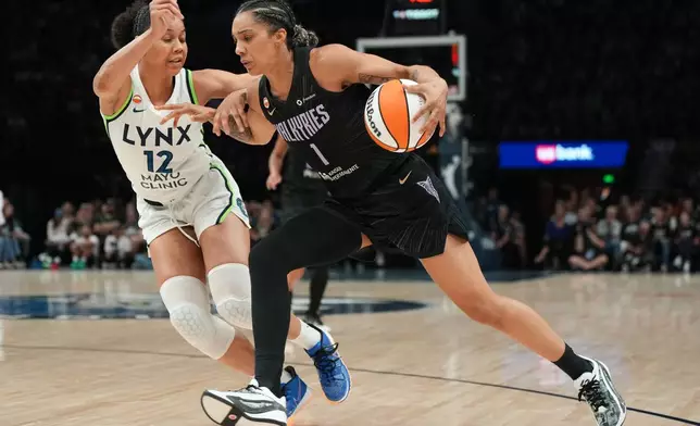Golden State Valkyries forward Gabby Williams (1) works toward the basket as Minnesota Lynx forward Nia Coffey (12) defends during the second half of a WNBA basketball game Monday, Aug. 24, 2026, in Minneapolis. (AP Photo/Abbie Parr)