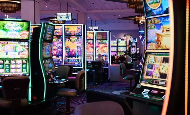 A person plays a slot machine at Harrah's Casino, owned by the Iowa Tribe of Oklahoma, in Chandler, Okla., Wednesday, Aug. 5, 2026. (AP Photo/Brittany Bendabout)