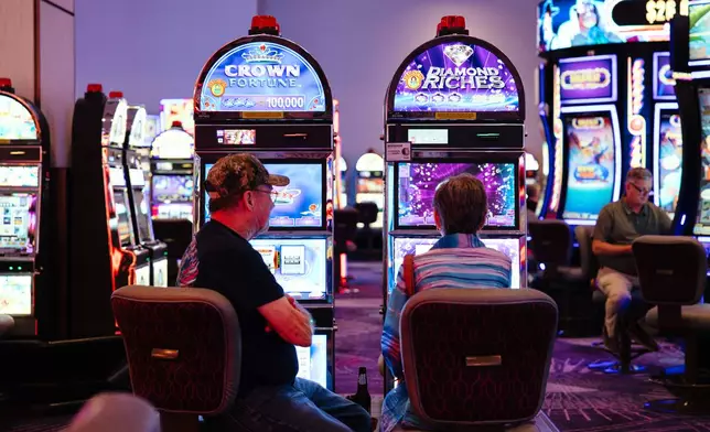 People play slot machines at Harrah's Casino, owned by the Iowa Tribe of Oklahoma, in Chandler, Okla., Wednesday, Aug. 5, 2026. (AP Photo/Brittany Bendabout)