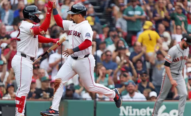 Boston Red Sox runner Mickey Gasper, cente, high fives with teammate Wilyer Abreu, left, after he scored in the fourth inning of a baseball game against the San Francisco Giants, Sunday Aug 23, 2026 in Boston. (AP Photo/Jim Davis)