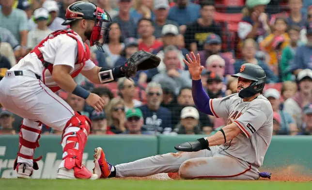 San Francisco Giants' Willy Adames, right, beats the throw to Boston Red Sox catcher Conner Wong, left, as he scores in the first inning of a baseball game Sunday, Aug. 23, 2026, in Boston. (AP Photo/Jim Davis)