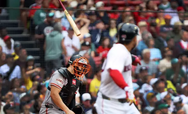 The bat of Boston Red Sox's Willson Contreras, right, just misses San Francisco Giants catcher Andrew Knizner, left, in the third inning of a baseball game, Sunday, Aug. 23, 2026, in Boston. (AP Photo/Jim Davis)