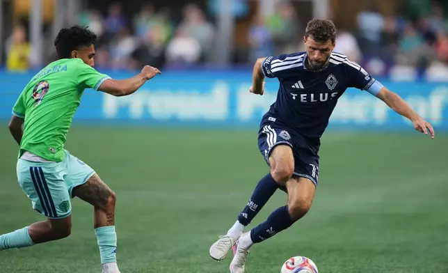 Vancouver Whitecaps forward Thomas Müller, right, moves the ball against Seattle Sounders forward Jesús Ferreira (9) during the first half of an MLS soccer match, Sunday, Aug. 16, 2026, in Seattle. (AP Photo/Lindsey Wasson)