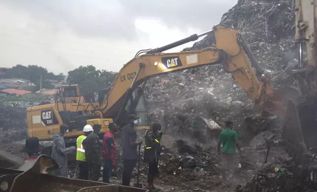 Rescue workers search through a heap of refuse after it collapsed at Conakry’s largest landfill, Guinea, Sunday, Aug. 23, 2026. (AP Photo/Fodo Toure)