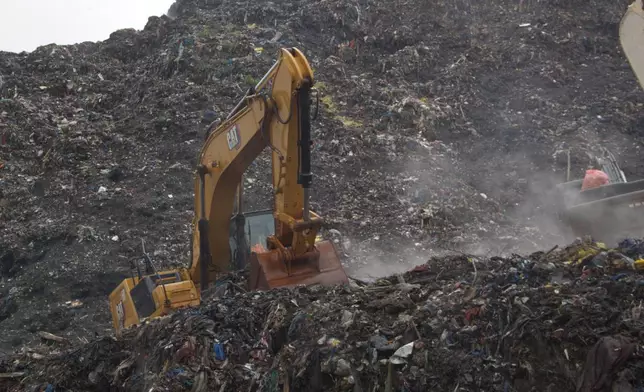 Rescue workers search through a heap of refuse after it collapsed at Conakry’s largest landfill, Guinea, Sunday, Aug. 23, 2026. (AP Photo/Fodo Toure)