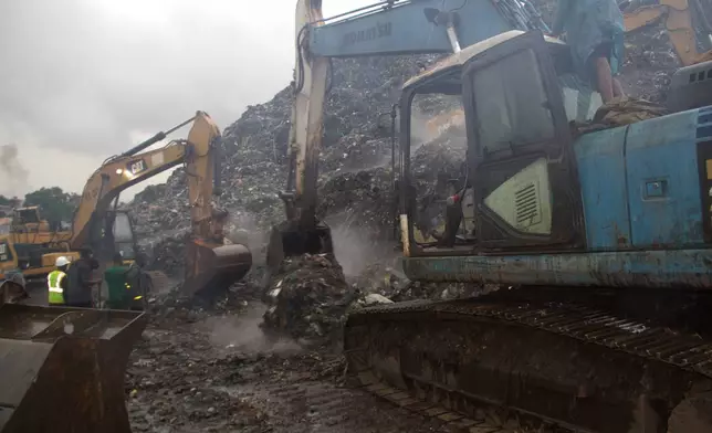 Rescue workers search through a heap of refuse after it collapsed at Conakry’s largest landfill, Guinea, Sunday, Aug. 23, 2026. (AP Photo/Fodo Toure)