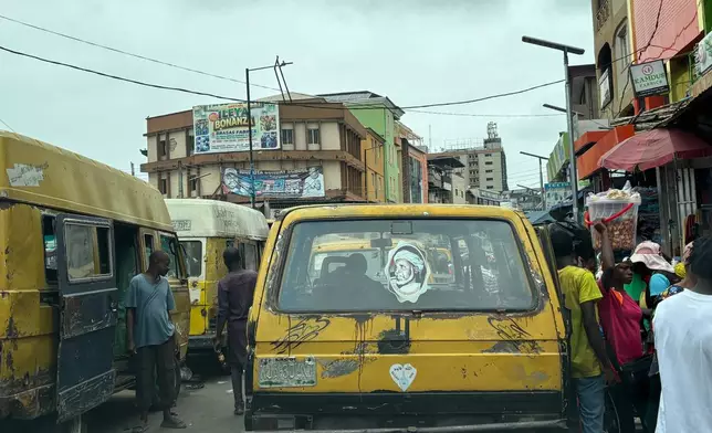 Commercial bus drivers wait for passengers inside a market in Lagos, Nigeria, Tuesday, Aug. 18, 2026. (AP Photo/Sunday Alamba)