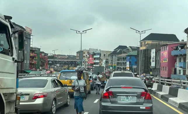 People sell their merchandise during rush hour traffic in Lagos, Nigeria, Tuesday, Aug. 18, 2026. (AP Photo/Sunday Alamba)