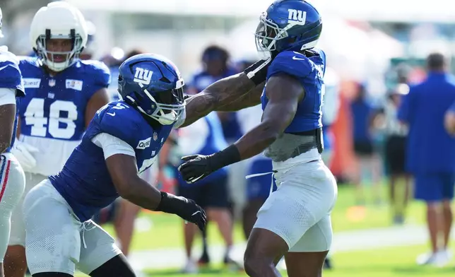New York Giants linebacker Kayvon Thibodeaux, left, and linebacker Brian Burns, right, do drills during a joint NFL football practice with the Miami Dolphins, Thursday, Aug. 20, 2026, in Miami Gardens, Fla. (AP Photo/Lynne Sladky)