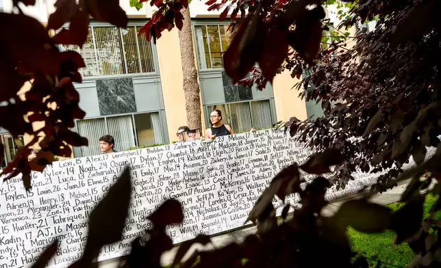 Lennon Torres of Heat Initiative holds a banner with names of young people who advocates say died as a result of social media outside the Ronald V. Dellums Federal Building and U.S. Courthouse on Tuesday, Aug. 18, 2026, in Oakland, Calif. (AP Photo/Noah Berger)