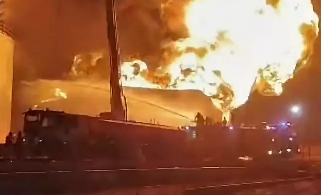 This frame grab from video shows firefighters working to contain a fire at the Zawiya oil refinery following a drone strike in Zawiya, Libya, Tuesday, Aug. 11, 2026. (Libyan Fire Department via AP)