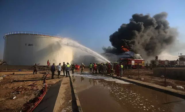 Firefighters work to contain a fire at the Zawiya oil refinery following a drone strike in Zawiya, Libya, Tuesday, Aug. 11, 2026. (AP Photo/Yousef Murad)