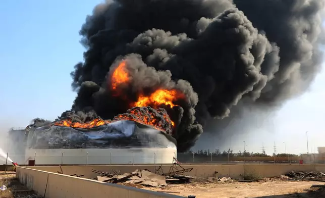 Flames and thick black smoke rise from a fuel storage tank at the Zawiya oil refinery following a drone strike in Zawiya, Libya, Tuesday, Aug. 11, 2026. (AP Photo/Yousef Murad)