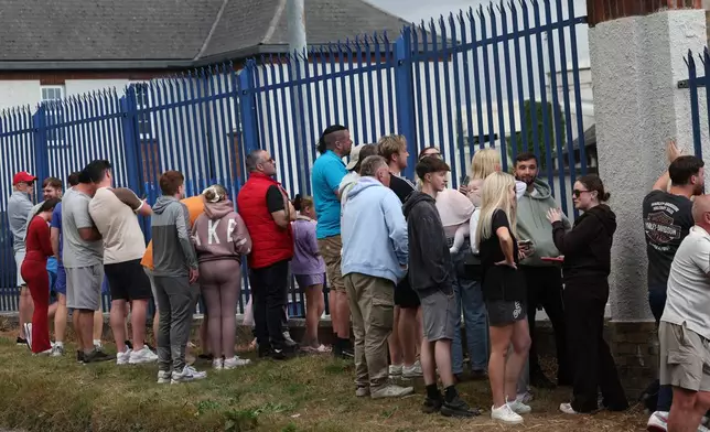 Members of the public outside Casement Aerodrome in Baldonnell, Ireland, Sunday, Aug. 9, 2026, where a Irish government plane believed to be carrying Daniel Kinahan landed, following him being extradited from Dubai, to face a charge of directing an organized crime group. (Damien Eagers/PA via AP)