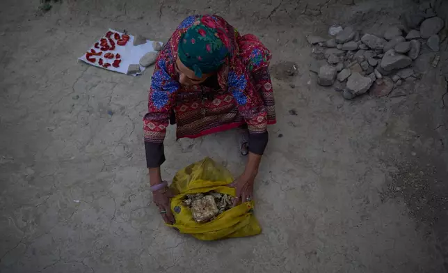 Sima checks dried meat she received during Eid al-Adha and preserved for the winter at her home in Kabul, Afghanistan, Wednesday, Aug. 12, 2026. (AP Photo/Nava Jamshidi)