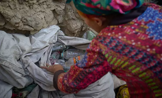 Sima sorts plastic bottles and metal cans she collected from the streets at her home in Kabul, Afghanistan, Wednesday, Aug. 12, 2026. (AP Photo/Nava Jamshidi)