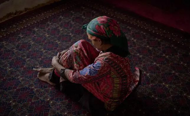 Sima sits barefoot on a carpet at her home in Kabul, Afghanistan, Wednesday, Aug. 12, 2026. (AP Photo/Nava Jamshidi)
