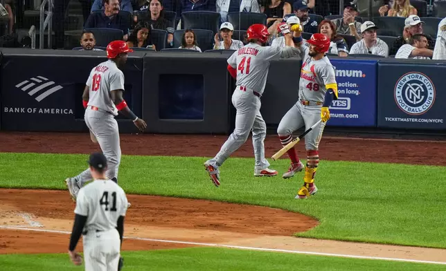 New York Yankees pitcher Tim Hill (41) watches as St. Louis Cardinals' Alec Burleson (41) celebrates with teammates Iván Herrera (48) and Jordan Walker (18) after hitting a two-run home run during the fourth inning of a baseball game Monday, Aug. 3, 2026, in New York. (AP Photo/Frank Franklin II)