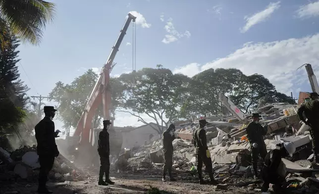 Soldiers clear debris three days after an earthquake struck Cali, Colombia, Thursday, Aug. 13, 2026. (AP Photo/Ivan Valencia)