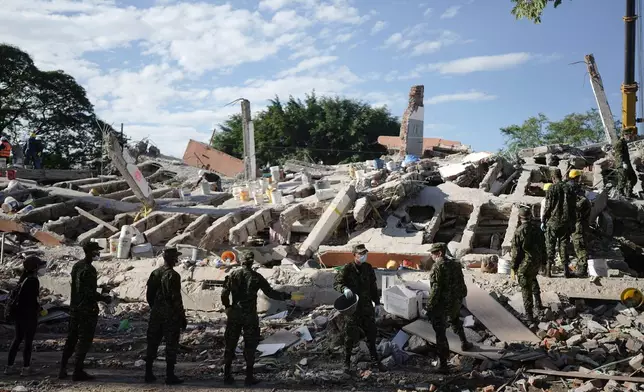 Soldiers clear debris three days after an earthquake struck Cali, Colombia, Thursday, Aug. 13, 2026. (AP Photo/Ivan Valencia)