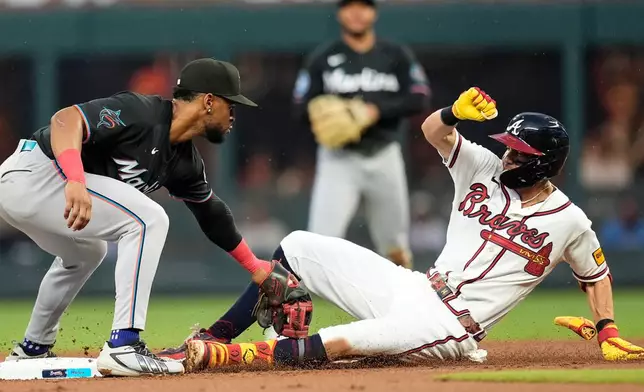 Miami Marlins shortstop Otto Lopez (6) makes the tag on Atlanta Braves' Mauricio Dubón (14) in the second inning of a baseball game, Thursday, Aug. 6, 2026, in Atlanta. (AP Photo/Mike Stewart)