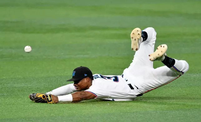 Miami Marlins right fielder Esteury Ruiz (3) dives for the ball hit by Washington Nationals' Dylan Crews, not pictured, during the fifth inning of a baseball game, Saturday, Aug. 22, 2026, in Miami. (AP Photo/Michael Laughlin)