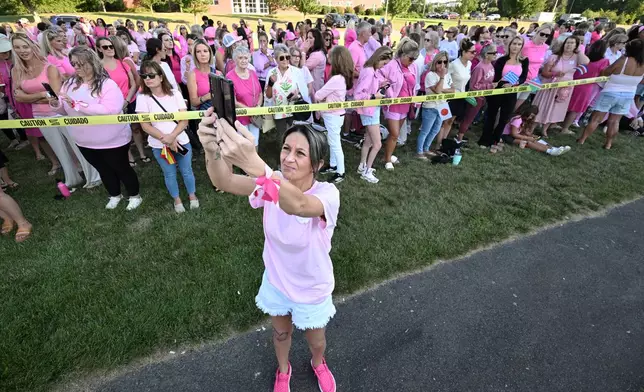 Aimee Breault of Acushnet, Mass., live-streams a demonstration in support of Lindsay Clancy outside Plymouth Superior Court, where Clancy is on trial in connection with the deaths of her three children, Thursday, Aug. 20, 2026, in Plymouth, Mass. (AP Photo/Josh Reynolds )