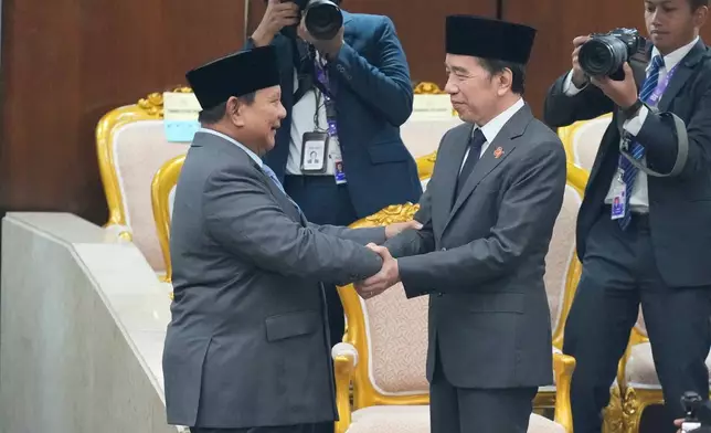 Indonesian President Prabowo Subianto, left, shakes hands with former president Joko Widodo after delivering his State of the Nation address ahead of the country's Independence Day at the parliament building in Jakarta, Indonesia, Friday, Aug. 14, 2026. (AP Photo/Dita Alangkara)