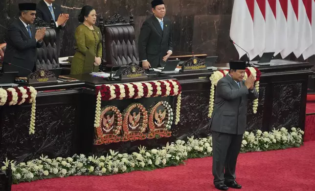 Indonesian President Prabowo Subianto, right, gestures after delivering his State of the Nation Address as, from left, the Chairman of the People's Consultative Assembly Ahmad Muzani, House Speaker Puan Maharani, and the Chairman of Regional Representative Council Sultan Bachtiar Najamudin applaud at the parliament building Jakarta, Indonesia, Friday, Aug. 14, 2026. (AP Photo/Dita Alangkara)