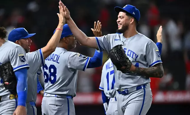 Kansas City Royals pitcher Steven Cruz, right, is greeted by teammates after defeating the Los Angeles Angels in a baseball game Friday, Aug. 14, 2026, in Anaheim, Calif. (AP Photo/William Liang)