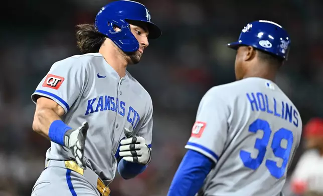 Kansas City Royals' Jac Caglianone, left, is greeted by first base coach Damon Hollins (39) after hitting a two-run home run during the fifth inning of a baseball game against the Los Angeles Angels, Friday, Aug. 14, 2026, in Anaheim, Calif. (AP Photo/William Liang)