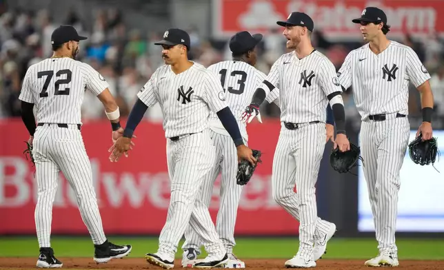 New York Yankees right fielder Spencer Jones, left fielder Cody Bellinger, and center fielder Trent Grisham, right to left, celebrate with teammates after winning a baseball game against the Boston Red Sox, Friday, Aug. 28, 2026, in New York. (AP Photo/Yuki Iwamura)