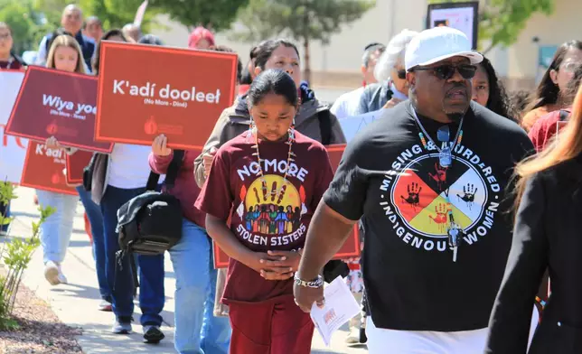 FILE - Tize W. Clark, right and his son, Zion Clark, participate in a walk to honor Native American and Indigenous relatives who have gone missing or have been killed as Missing and Murdered Indigenous Persons Awareness Day is marked in Albuquerque, New Mexico, on May 5, 2025. (AP Photo/Susan Montoya Bryan,File)