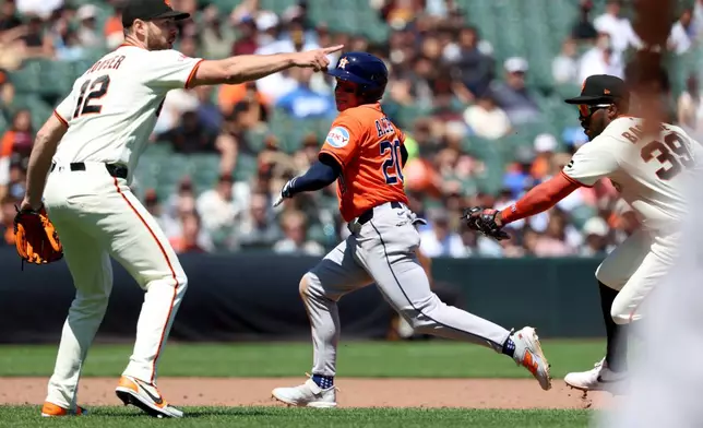 Houston Astros' Nick Allen (20) is tagged out in a rundown by San Francisco Giants shortstop Osleivis Basabe (39) in front of Adrian Houser (12) during the sixth inning of a baseball game in San Francisco, Wednesday, Aug. 12, 2026. (AP Photo/Jed Jacobsohn)