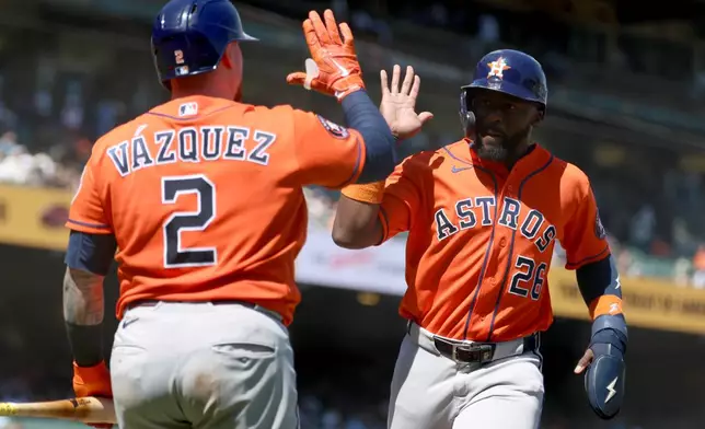 Houston Astros' Taylor Trammell (26) is congratulated by Christian Vázquez (2) after scoring on a sacrifice fly hit by Nelson Velazquez during the eighth inning of a baseball game against the San Francisco Giants in San Francisco, Wednesday, Aug. 12, 2026. (AP Photo/Jed Jacobsohn)