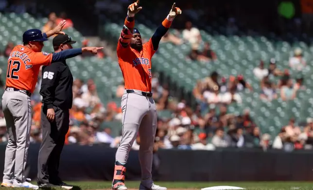 Houston Astros' Taylor Trammell (26) gestures to teammates after hitting a triple during the eighth inning of a baseball game against the San Francisco Giants in San Francisco, Wednesday, Aug. 12, 2026. (AP Photo/Jed Jacobsohn)