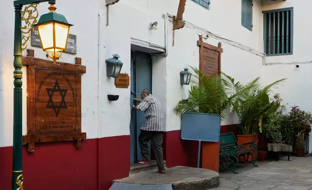 Keith Hallegua, a Paradesi Jew, opens the door to enter the 458-year-old Paradesi Synagogue in the historic Jew Town neighborhood of Kochi, India, Thursday, May 21, 2026. (AP Photo/Aijaz Rahi)
