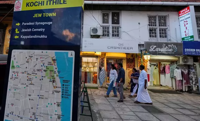Visitors walk past a sign featuring a map of Kochi and details about the Paradesi Synagogue and the Jewish cemetery in the historic Jew Town neighborhood of Kochi, India, Thursday, May 21, 2026. (AP Photo/Aijaz Rahi)