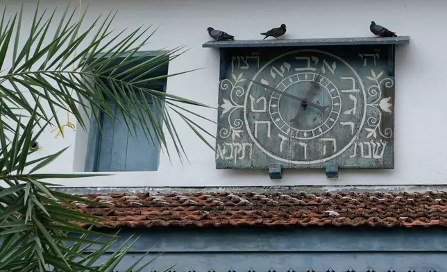 Birds sit on the wooden ledge above an ornate Hebrew clock on the 458-year-old Paradesi Synagogue in the historic Jew Town neighborhood of Kochi, India, Wednesday, May 20, 2026. (AP Photo/Aijaz Rahi)
