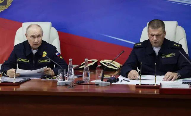 Russian President Vladimir Putin, left, and Russian Pacific Fleet Commander-in-Chief Admiral Viktor Liina attends a meeting with navy officers on board of the Varyag missile cruiser of the Pacific Fleet during a military exercise near Yuzhno-Sakhalinsk, on Sakhalin Island, Russia, Wednesday, Aug. 12, 2026. (Gavriil Grigorov, Sputnik, Kremlin Pool Photo via AP)