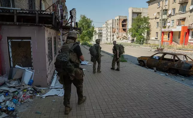 In this photo provided by Ukraine's 93rd Kholodnyi Yar Separate Mechanized Brigade press service and taken Monday, Aug. 10, 2026, Ukrainian soldiers walk along the street in the frontline town of Druzhkivka, Donetsk region, Ukraine. (Iryna Rybakova/Ukraine's 93rd Mechanized Brigade via AP))