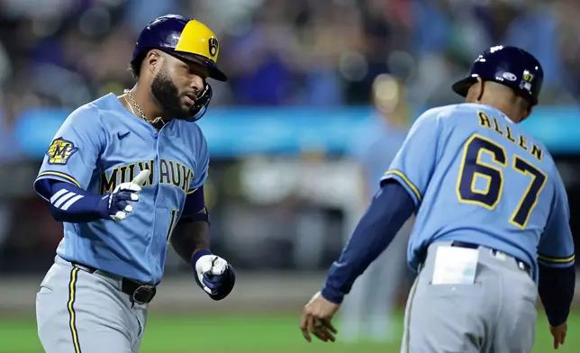 Milwaukee Brewers' Jackson Chourio, left, celebrates with first base coach Spencer Allen (67) after hitting a two-run home run during the eighth inning of a baseball game against the New York Mets, Thursday, Aug. 27, 2026, in New York. (AP Photo/Adam Hunger)